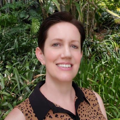 A smiling person in a garden.