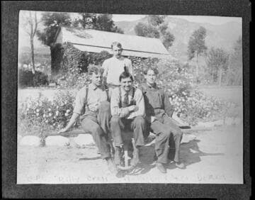 Four men of the operating crew sitting outside a company facility at Mill Creek #1 Hydro Plant. The men are E.P. Chase