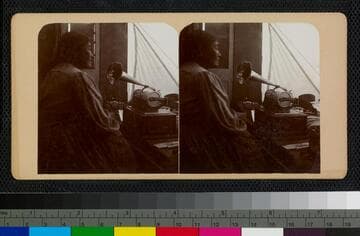 Ramona Lubo speaking into George Wharton James' graphophone, inside his wagon