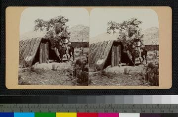 Hualapai Indian on a horse in front of a wooden shelter
