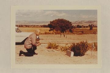 Dock Marston at the grave of Frank V. Goodman.  The wooden markers in the background are the graves of Nat Galloway and his wife.  Vernal Cemetery