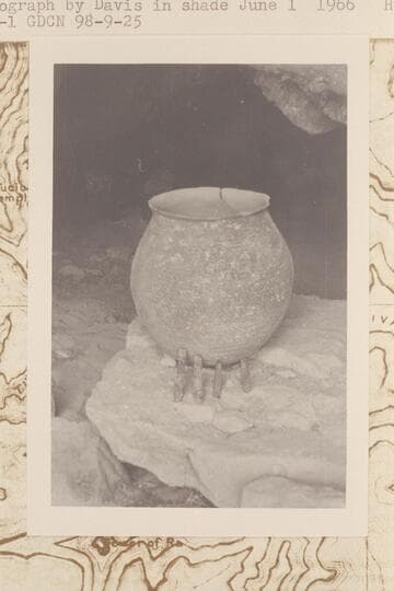 Olla and prehistoric corncobs at mouth of Olla Vieja Cave where they were found in 1966, May 31, by Donald Davis.  Photograph taken in shade