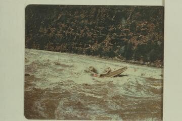 Frank Wright at the oars and Mary Beckwith riding the stern of the sadiron "Sandra", Upper Disaster Rapid