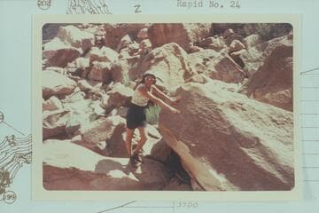 Jean Bennett points to Nevills inscription at head of Rapid 23 in Cataract Canyon