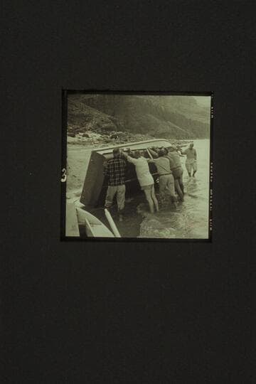 The "Rattlesnake" rolled up at Tapeats Creek for repairs. Left to right: Eisaman, Taylor, Cutler, Belknap, Sanderson and Masland. A rock in Bedrock Rapid had sliced the bottom requiring a patch