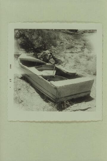 Bert Loper's wrecked boat going to pieces on the bank near Mile 41