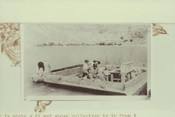 Arthur c.Waller sits in the scow near the desk.  Lees Ferry.  Copy of print in Waller collection