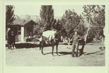 Katherine Wilson and the Wilsons' cabin.  Cummings Mesa in background.  Photo by L. F. H. Lowe with the Rust party