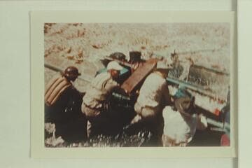 Crew dragging on the pontoon trying to free it from the nose of the rock in Bedrock Rapid. Allan Smith; Smokey Patton; Smuss Allen; Walt Emery. The crew are struggling to get the pontoon off the rock immediately after it hit