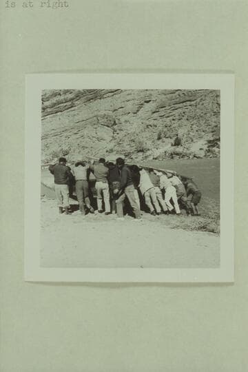 Crew rolling the "Emma Dean" to attach a cable. Filming of "The Colorado River Story" by Disney above Moab near Castle Creek. Tom Coleman, left, Jim Drury is second, Russ Haverick with long coat, center, Frank Turner in white pants, Roy Bolton, right