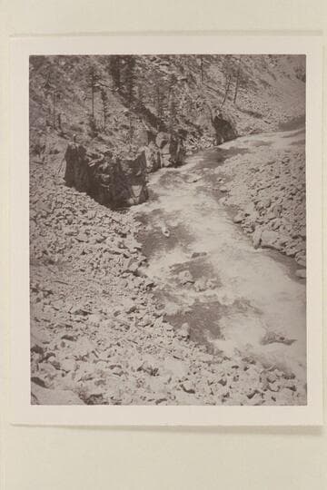 Harold H. Leich in his folding kayak "Rob Roy" edging along shore in Byers Canyon