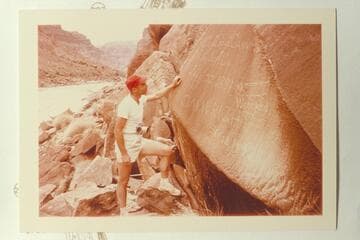 Jorgen Visbak reads the Best expedition and the Wright inscriptions at Mile 204 1/2, Cataract Canyon. Note the edge of 203 Mile rock over Jorgen's head