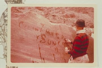 Dock Marston running water onto the letters of the Best Expedition inscription near the river at Mile 204 1/2 right bank