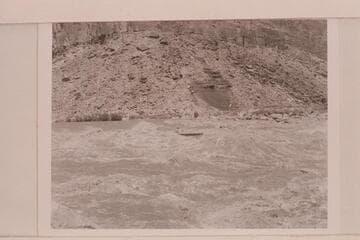 Jimmy Jordan pilots the "June Bug" through Badger Creek Rapid. Ivins McDonald is passenger