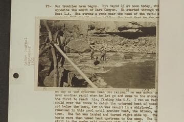 USGS boat on rocks in Dark Canyon Rapid.  Lint is on shore and Emery and Ellsworth on the boat.  LaRue Colorado River album #173