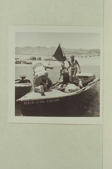 The "Maid of the Canyon" arrives at Boulder City.  Roy Bolton waves as Jeff Marston steps forward.  The Marine flag is being removed
