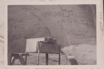 Autographs and dates on wall of cave. The name Bert Loper is cut in the sandstone