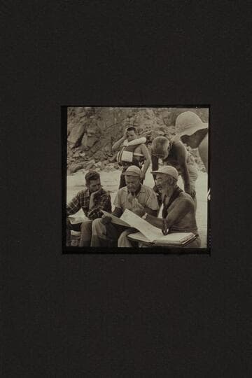 Briefing at Diamond Creek. Hugh Cutler sits lower left. Rod Sanderson and Marston work on the details from the charts. Buzzy Belknap indicates that all the talky-talk gives him a pain. Masland appears to find it interesting
