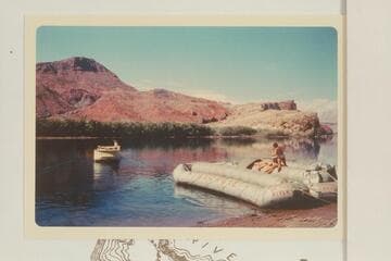 The deck boat backs into the river for a trial run. Georgie White struggles with her boloneys at right