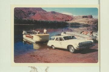 The deck boat is launched at Lees Ferry.  Georgie White works on her boloneys at right