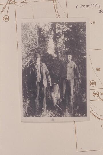 Sharp and Stone bringing what appears to be the fireless cooker into camp #1, about Mile 381.5 left bank below Bitter Creek