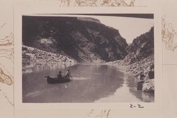McCuish at the oars and John S. Wilbur steering a folding boat used in prospecting in the lower end of Grand Canyon in the spring of 1904. Taken at Mile 224 1/2.  The boat is heading upriver