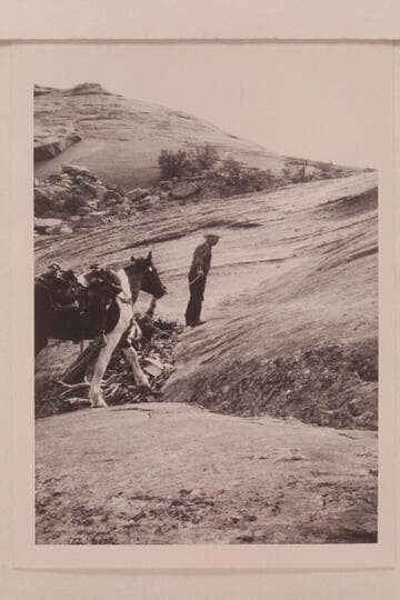 Bill Belknap leads his horse up the slickrock trail west of Nasja Creek