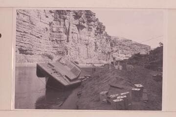 The twin jet "Little Squirt" rolled on the bank at Mile 4 for repair. After temporary patching the party returned to Lees Ferry and abandoned the trip until June 18 when a complete run of the Canyon was made. This boat became known as the "Big Red."