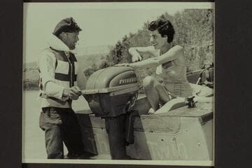 Jimmy Jordan explains the Evinrude motor to Maradel Marston, Paria Riffle
