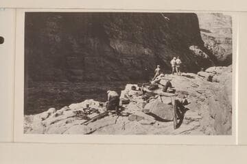 The two tons of supplies on the rocks at lower end of Lava Escarpment Rapids, the supplies having been carried around are now ready to be loaded in the boats. L to R: Koms, Blake, Lint, Stabler and Birdseye