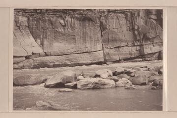 Undercut cliff at Triplet Rapid. Low water. Boat is the "Galloway" piloted by Lug Larsen