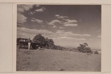 Chet Bundy stands near our car near the top of Mt. Logan; lower Grand Canyon in distance