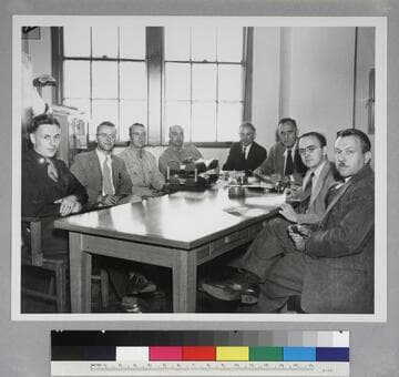 Edwin Powell Hubble and seven unidentified men in an office at the U.S. Army Ballistic Laboratory, at Aberdeen Proving Ground