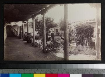 People in the courtyard of an adobe building