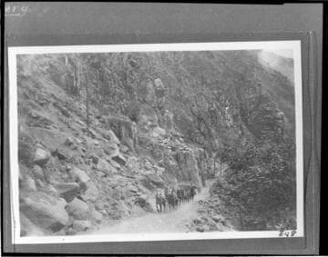 A section of penstock for Kern River #1 Hydro Plant being hauled up the trail in Kern River Canyon by a team of horses