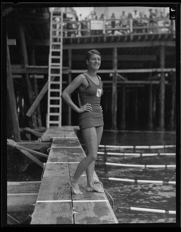 Woman swimmer posing next to lanes of swimming competition, Santa Monica