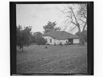 Unidentified house with a dog and child in the yard