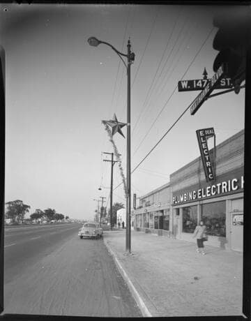 Christmas decoration on streetlight in front of Plumbing & Electric storefront at Hawthorne & 147th Street