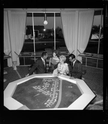 People reviewing sale of parcels on a plot map for an upscale housing development