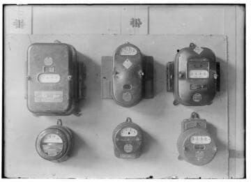 Six electric meters mounted in a group. All are different designs