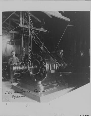 A.W. Decker standing beside a generator at the Pomona Plant