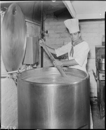 Chef stirring large pot of soup