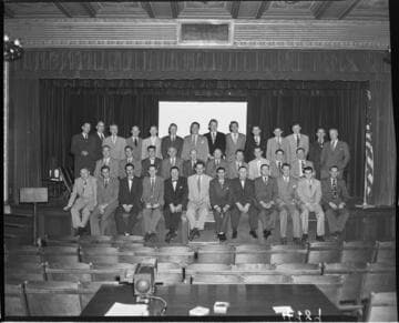 Group of men in suits on stage at Edison Auditorium