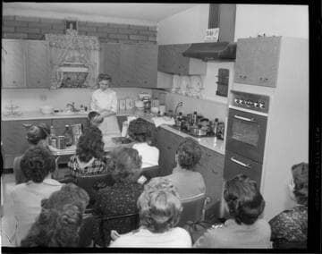 Cooking demonstration promoting electric appliances to a group of women with 9 variants
