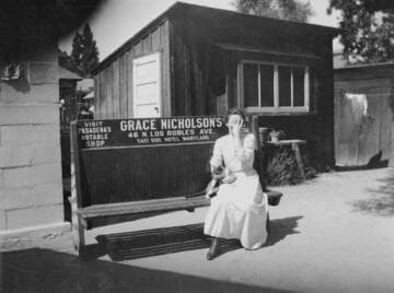 Unidentified woman on bench advertising Grace Nicholson's store