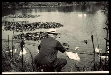 Henry E. Huntington feeding ducks and swans in the reservoir, circa 1915