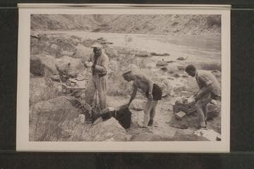 Rod Sanderson and Dock Marston bathe the dishes.  Second camp in Marble Canyon.  President Harding Rapid.  Sanderson; Marston; Beer