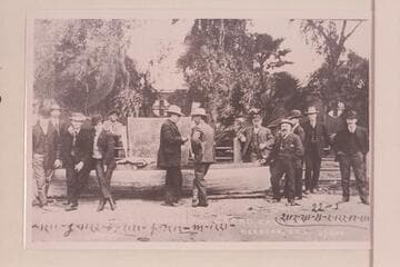 The "Utah" at Needles. Charles Russell stands right center and talking with the man in front of the sign. The sign is the after deck of the skiff