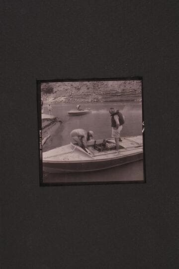 The boats used in the 1954, June traverse of Grand Canyon.  Sanderson has fired up the motors of the "Rattlesnake" while Cutler holds the bow line.  Marston is stowing the lines of the "BOOTOO" while Masland looks on