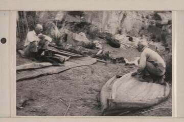 Dave Rust assembling his folding canvas boats. George C. Fraser watches at left